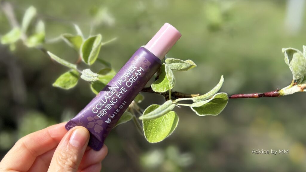 Mizon Collagen Power Firming Eye Cream fotografiată pe o ramură verde. Formula conține mai mulți siliconi, inclusiv cyclomethicone, cyclopentasiloxane, dimethicone și polysilicone-